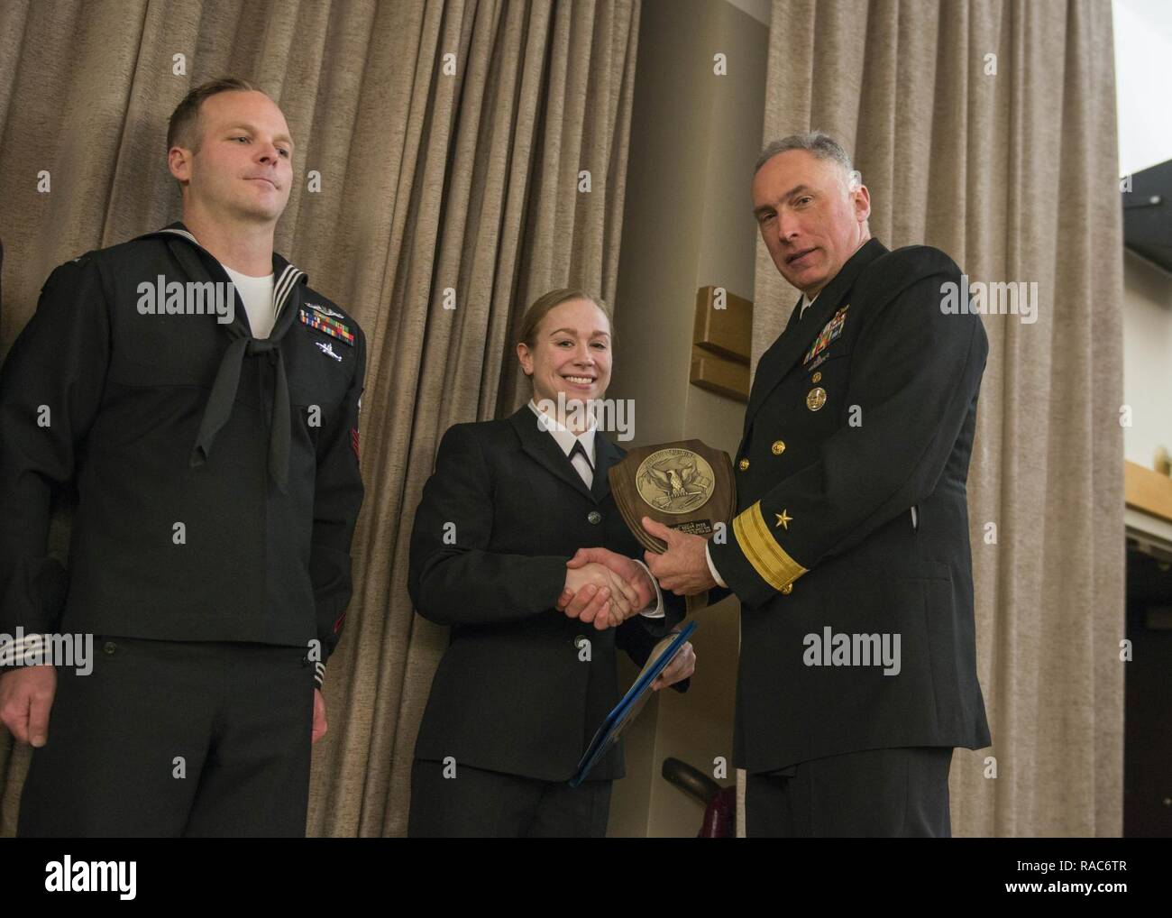 BANGOR, Wash. (Jan. 17, 2017) Rear Adm. John Tammen, commander, Submarine Group 9, congratulates Sonar Technician (Surface) 2nd Class Kegan Dyer, from Pownal, Maine, assigned to Naval Ocean Processing Facility, Whidbey Island, on becoming the 2016 Sea Junior Sailor of the Year. The Sailor of the Year Program was introduced in 1973, by former Chief of Naval Operations Adm. Elmo Zumwalt, to recognize superior performance at every command. Stock Photo