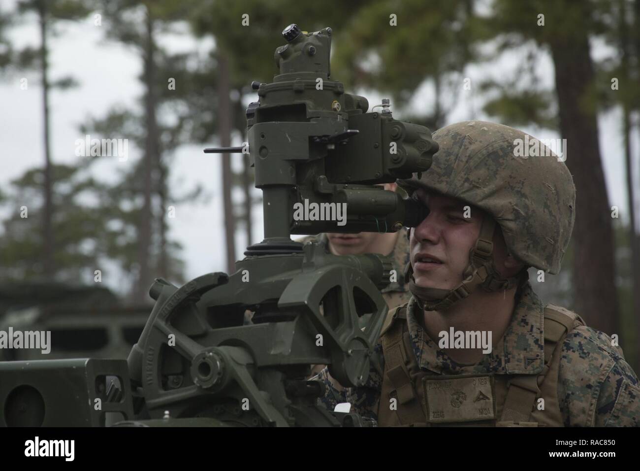 Lance Cpl. Christopher Ploof aims down the sight of an M777A2 towed 155mm howitzer at Camp Lejeune, N.C., Jan. 18, 2017. Ploof is attending the Artillery Training School as part of a certification course to become a gunner for the howitzer, which takes approximately two weeks to complete. Ploof is a field artillery cannoneer with 1st Battalion, 10th Marine Regiment, 2nd Marine Division. Stock Photo