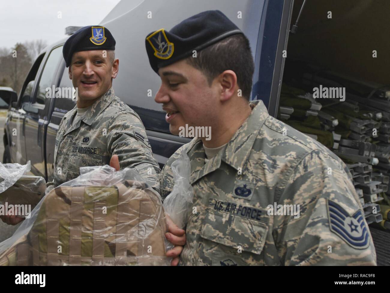 Airman First Class Travis Roemmele, passes equipment to Technical Sergeant Joshua Ramirez, 108th Security Forces Members bucket line style out of a storage unit at the 108th Wing, Joint Base McGuire-Dix-Lakehurst, N.J., Jan. 17, 2017. The 108th Security Forces are preparing to support Local Emergency Services in Washington D. C. during the 58th Presidential Inauguration. Stock Photo
