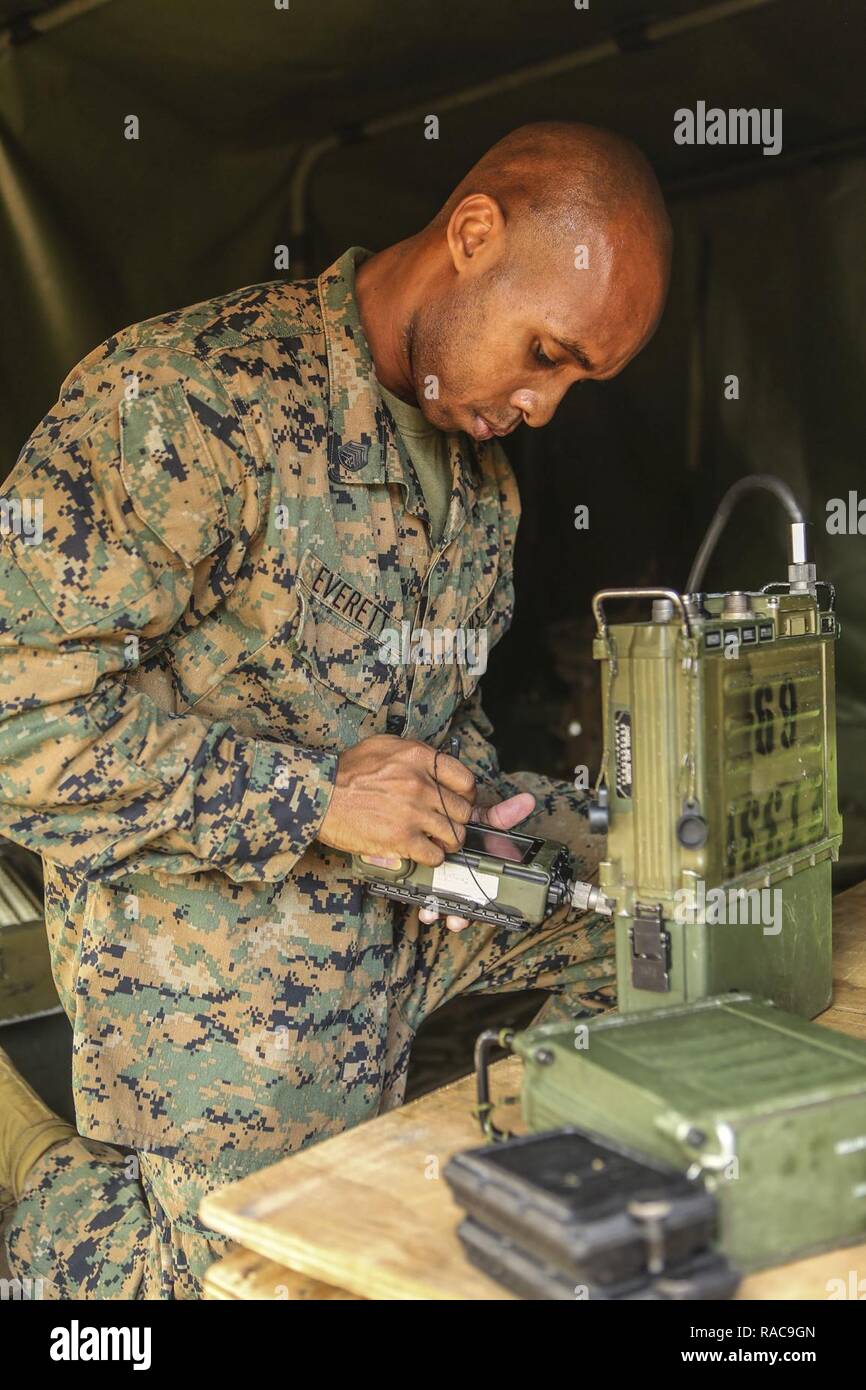 U.S. Marine Corps Staff Sgt. Matthew B. Everett, Radio Chief, Headquarters Company, Combat Logistics Regiment (CLR) 2, 2nd Marine Logistics Group, programs the AN/PRC 117F Multiband Manpack Radio during a command post exercise (CPX) at Landing Zone Canary on Camp Lejeune, N.C., Jan. 18, 2016. CLR-2 conducted the CPX in preparation for an upcoming deployment. Stock Photo