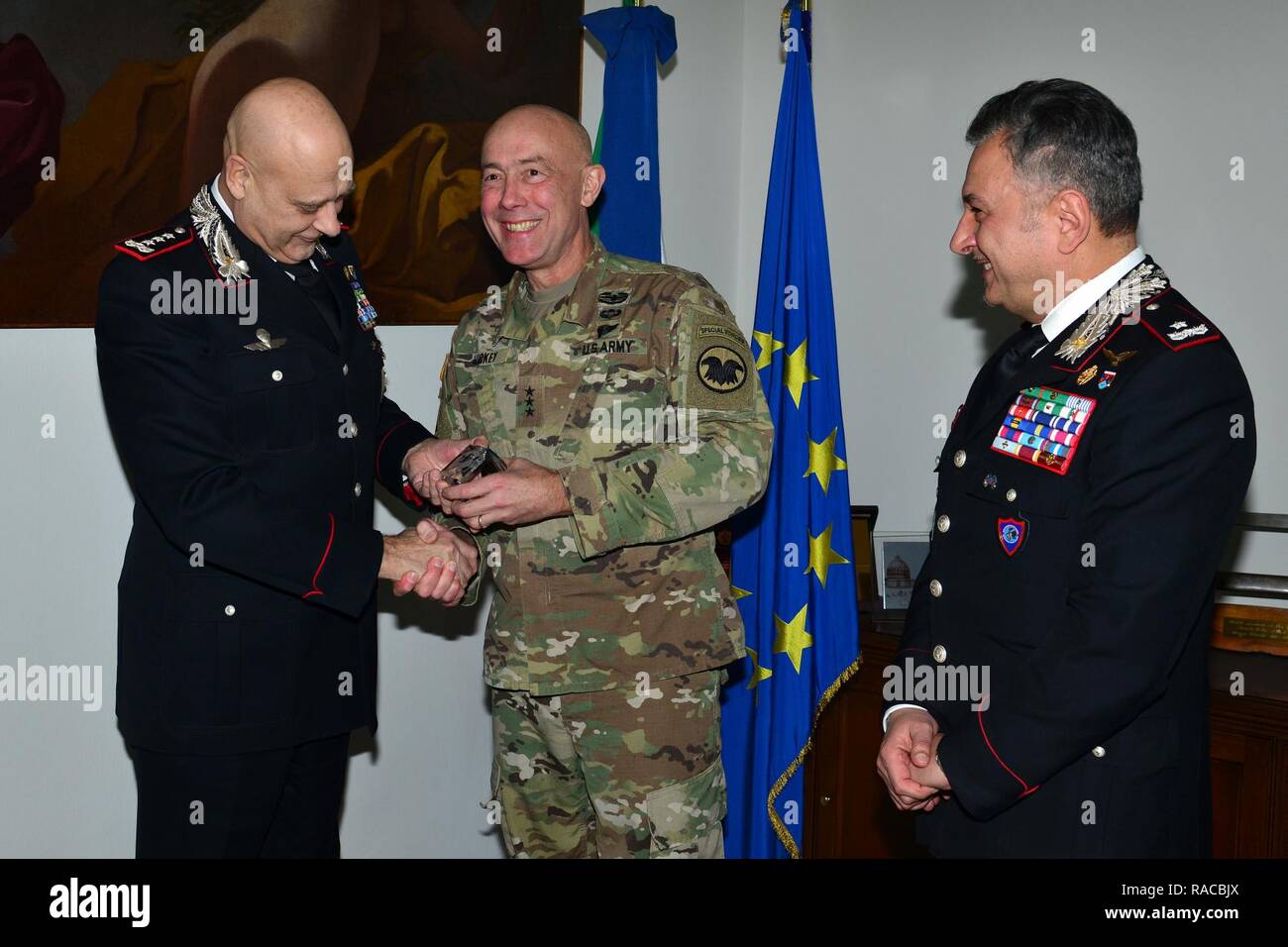 Brig. Gen. Giovanni Pietro Barbano (right), Center of Excellence for Stability Police Units (CoESPU) director, observa, Lt. Gen. Charles D. Luckey (center), Commanding General U.S. Army Reserve Command, present a gift at Lt. Gen Vincenzo Coppola (left), Commanding General “Palidoro” Carabinieri Specialized and Mobile Units during visit at Center of Excellence for Stability Police Units (CoESPU) Vicenza, Italy, January 20, 2017. Stock Photo