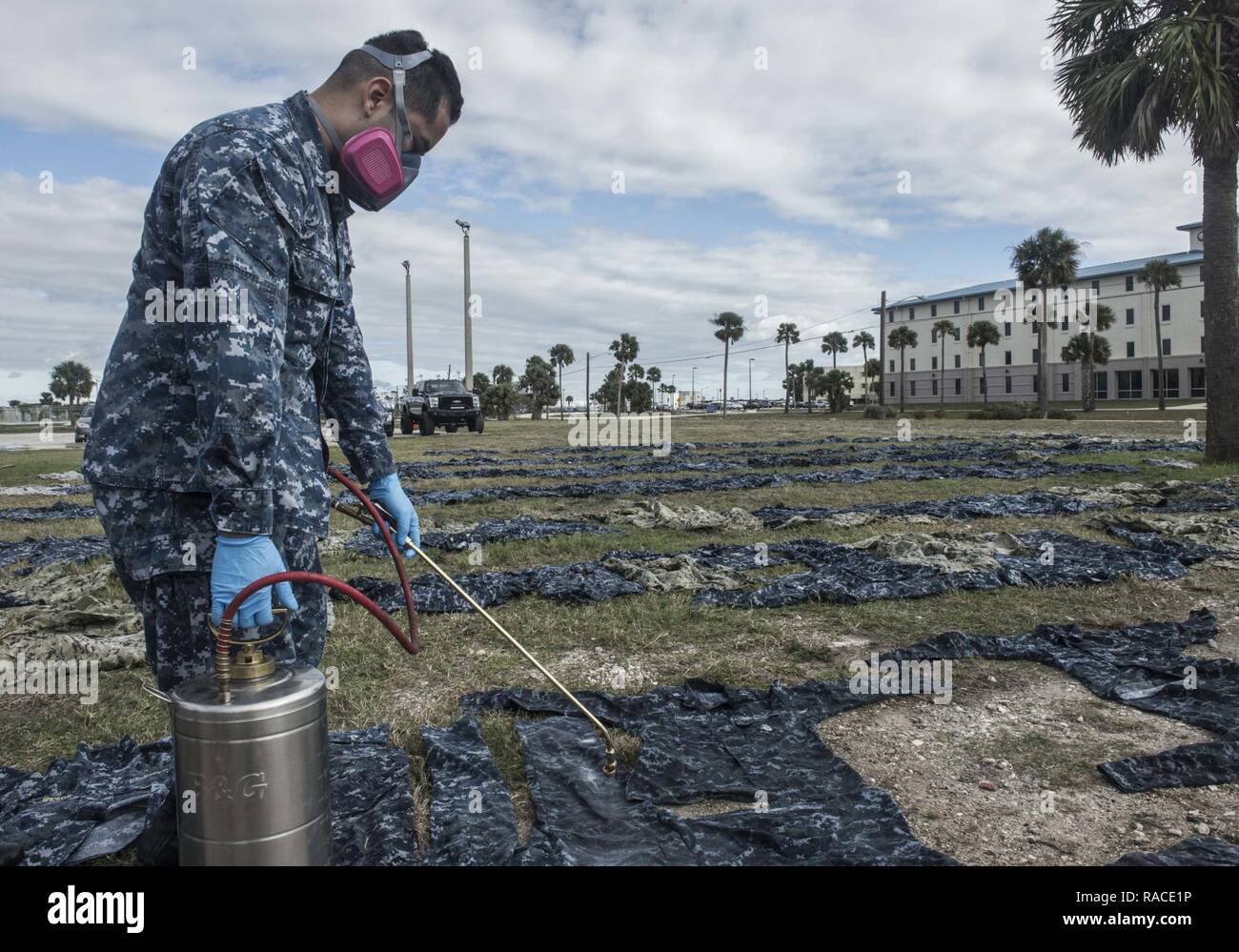 (Jan. 23, 2017) MAYPORT, Fla. - Hospital Corpsman 3rd Class Joshua Nieto of Navy Entomology Center of Excellence (NECE) Jacksonville, Fla.,  applies the insect repellant Permethrin to uniforms at Naval Station Mayport, Fla. Treating uniforms is one of many preparations  service members are taking before departing on Continuing Promise 2017 (CP-17). Continuing Promise 2017 is a U.S. Southern Command-sponsored and U.S. Naval Forces Southern Command/U.S. 4th Fleet-conducted deployment to conduct civil-military operations including humanitarian assistance, training engagements, and medical, dental Stock Photo