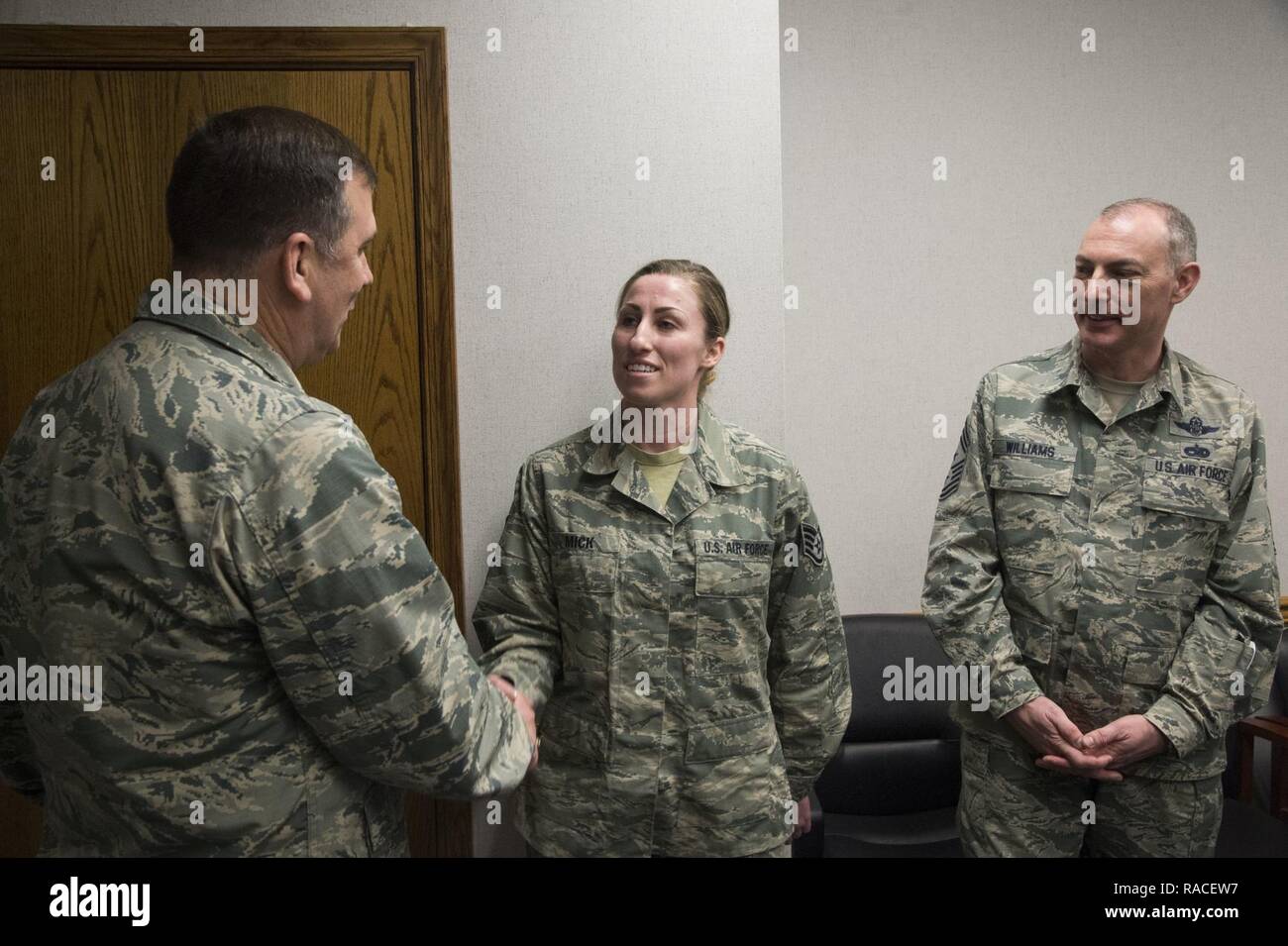 Maj. Gen. Christopher J. Bence, U.S. Air Force Expeditionary Center commander, and Chief Master Sgt. Larry Williams, the U.S. Air Force Expeditionary Center Command Chief, recognize Staff Sgt. Nikki Mick, a supply supervisor assigned to the 621st Air Mobiilty Operations Squadron, with an Air Force coin during a tour of the 621st Contingency Response Wing at Joint Base McGuire-Dix-Lakehurst, N.J., January 23, 2017. Bence recognized nine Airmen for their outstanding performance during the visit. Stock Photo