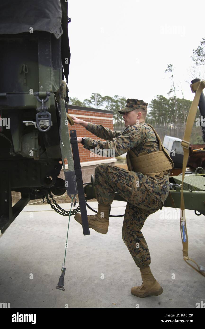 A Marine climbs into a tactical vehicle during a Strategic Mobility Exercise aboard Marine Corps Air Station Cherry Point, N.C., Jan. 20, 2017. Marines assigned to Marine Air Support Squadron 1, Marine Air Control Group 28, 2nd Marine Aircraft Wing simulated troop movement in response to a limited/ no-notice mock deployment of a Direct Support Center with extensions in support of overseas contingency operations. Marines must maintain their ability to react effectively and in a timely matter when called upon to support operations anywhere in the world. Stock Photo