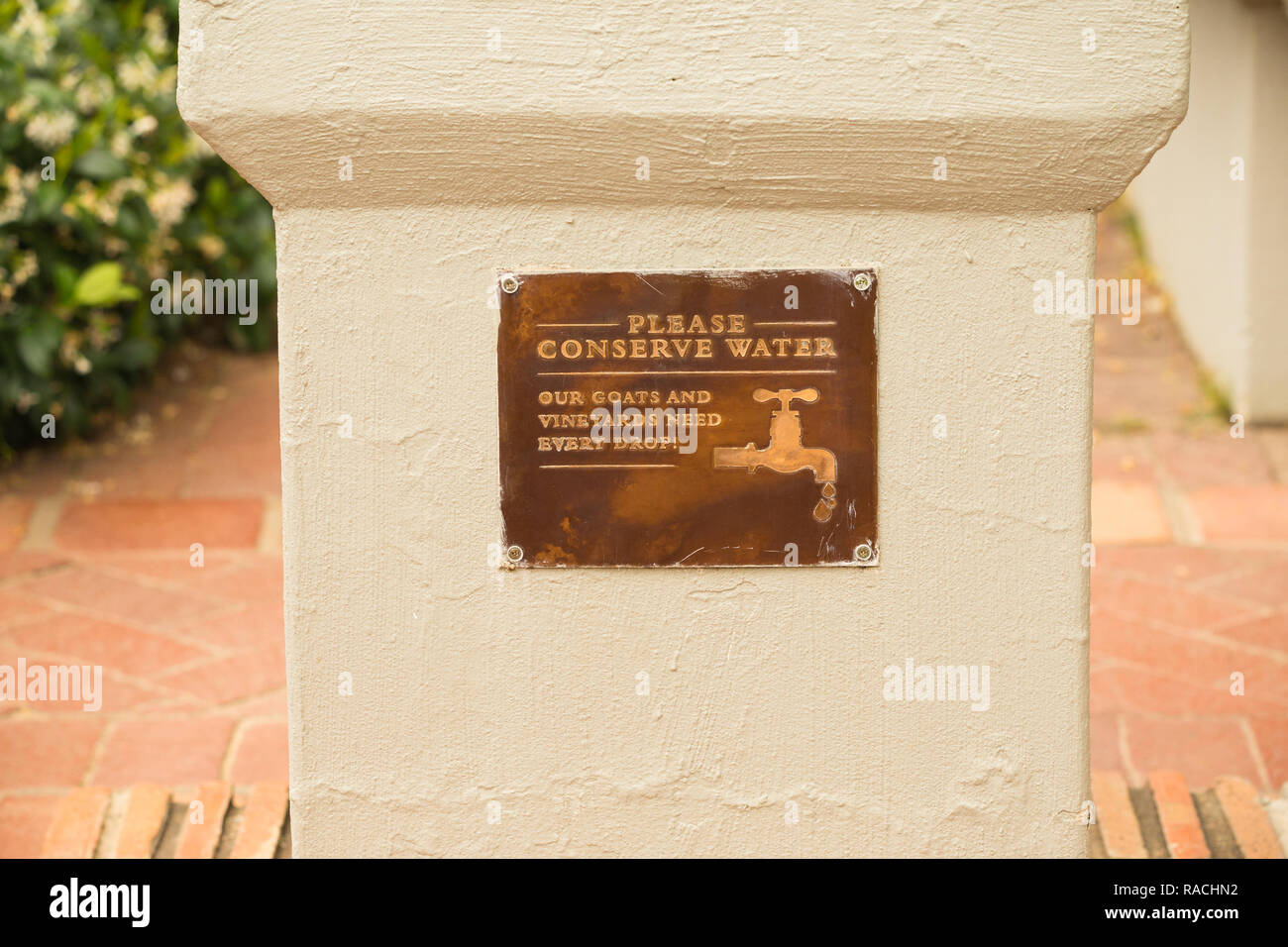 water conservation message written on copper plaque on wall in garden environmental friendly message for water scarcity in Cape Town South Africa Stock Photo
