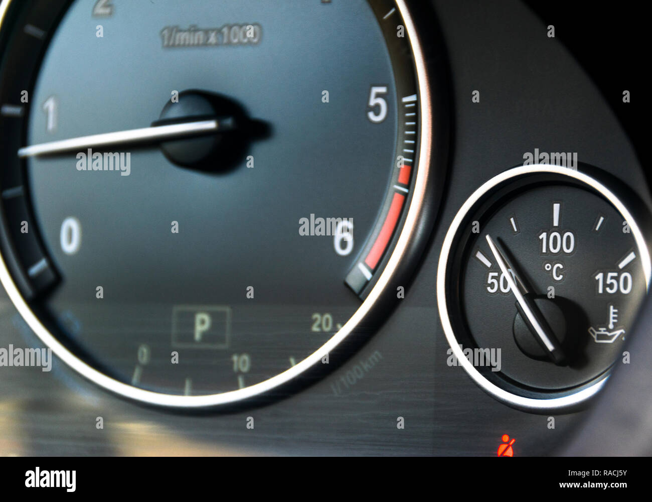 Coolant temperature gauge and tahometer on a car's dashboard. Car
