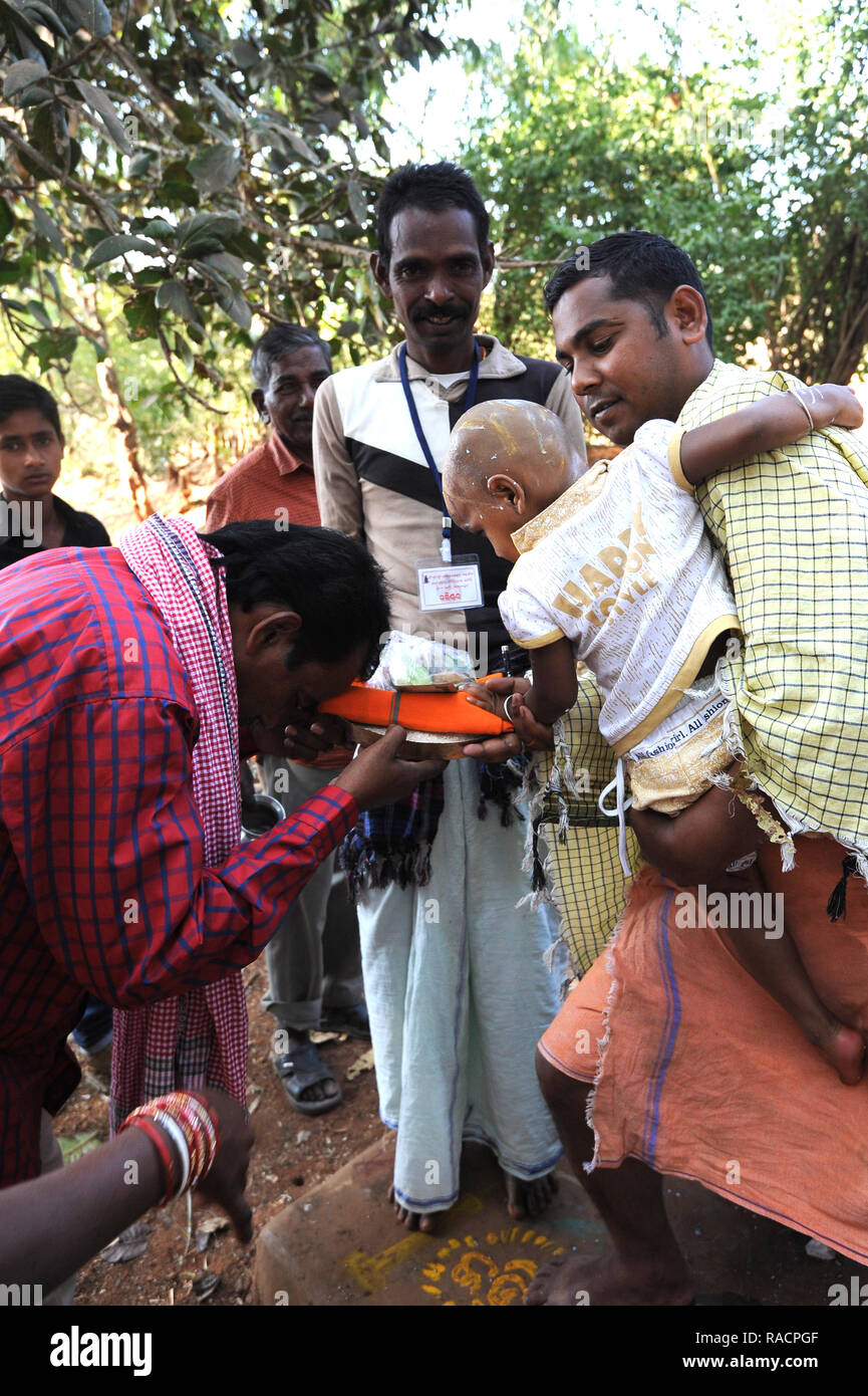 Mali tribesman offering puja gift to temple pundit after shaving his