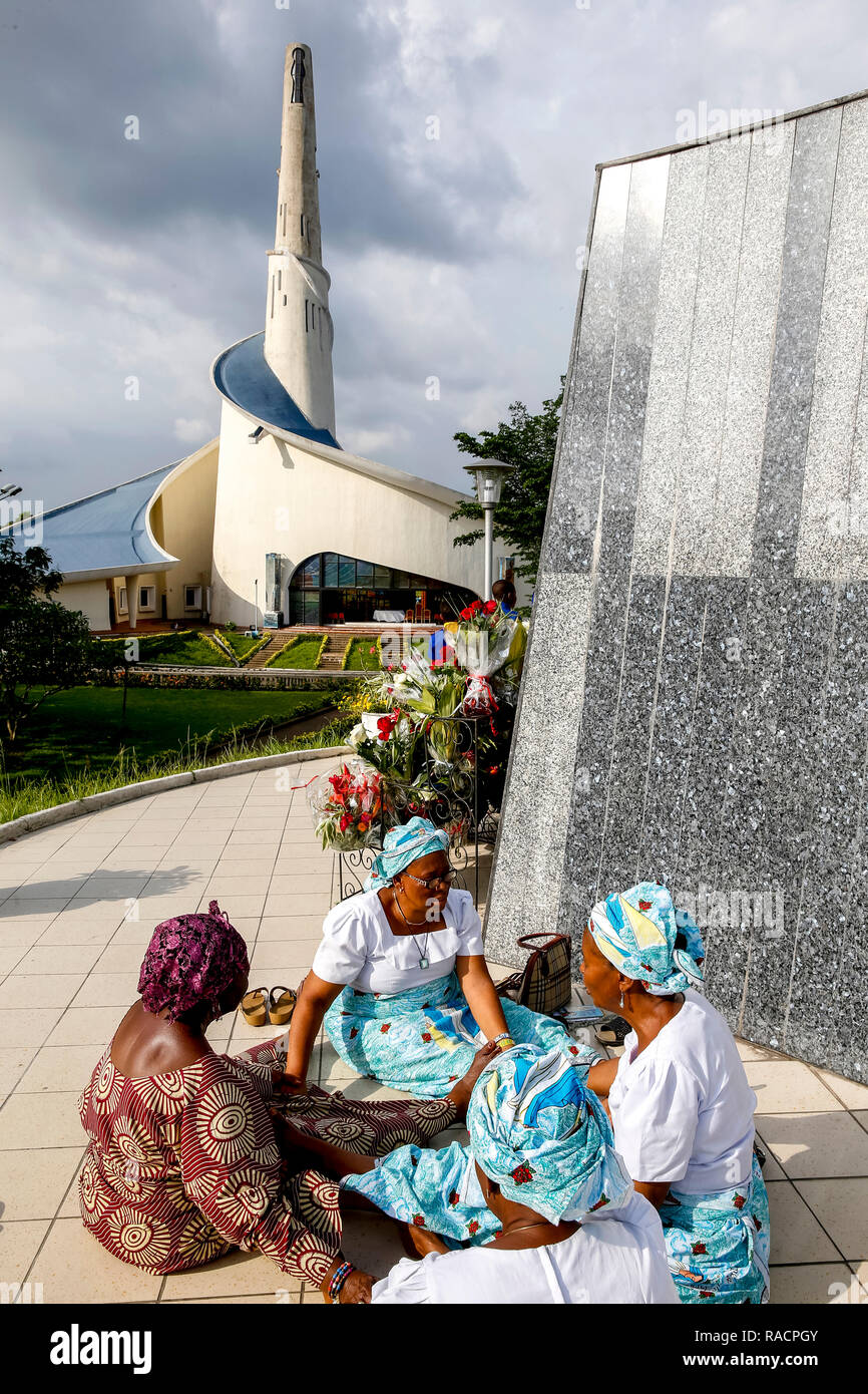 Pilgrims praying and joining hands at Our Lady of Africa Catholic sanctuary, Abidjan, Ivory Coast, West Africa, Africa Stock Photo