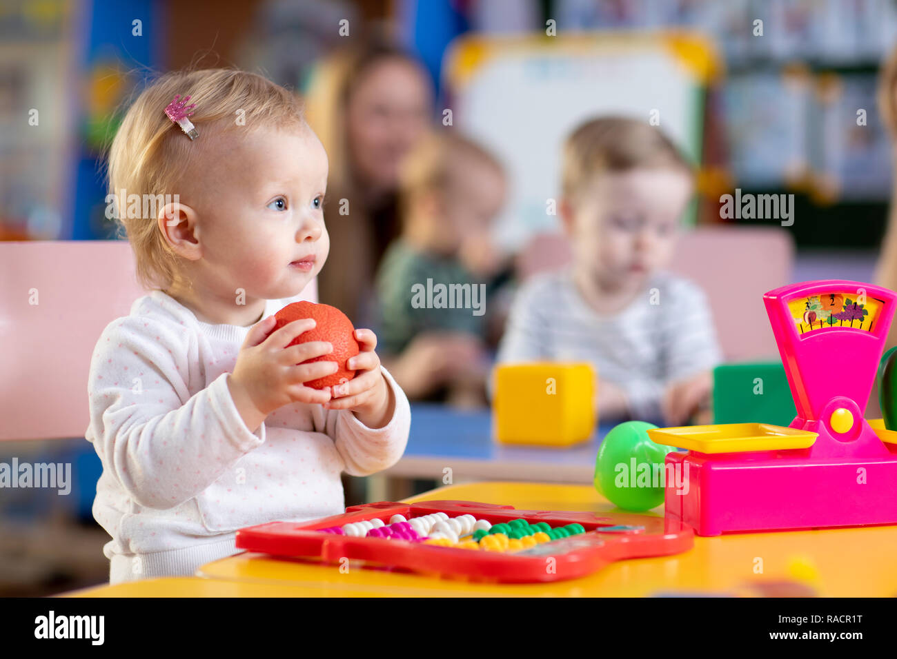 Cute little child girl playing with toys in nursery Stock Photo - Alamy