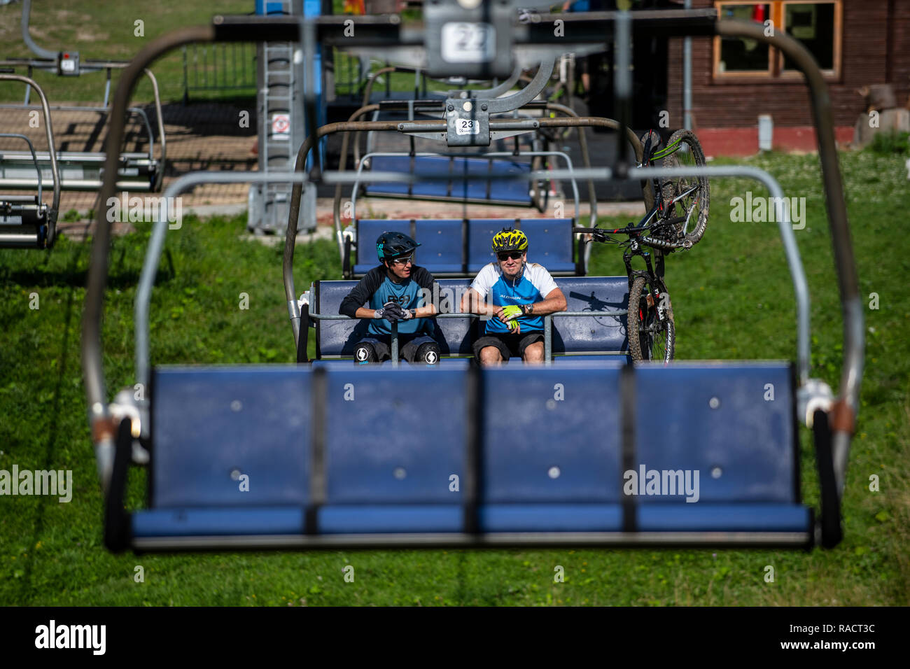 Two men with mountain bikes ride a chairlift at Malinô Brdo bike park near Ružomberok in Slovakia. Stock Photo
