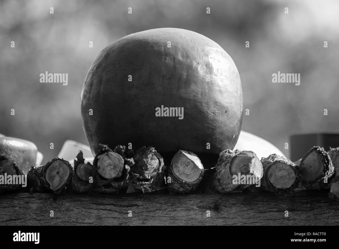 Traditional African cooking pot also known as the calabash set to dry on an elevated wooden make shift table. Stock Photo