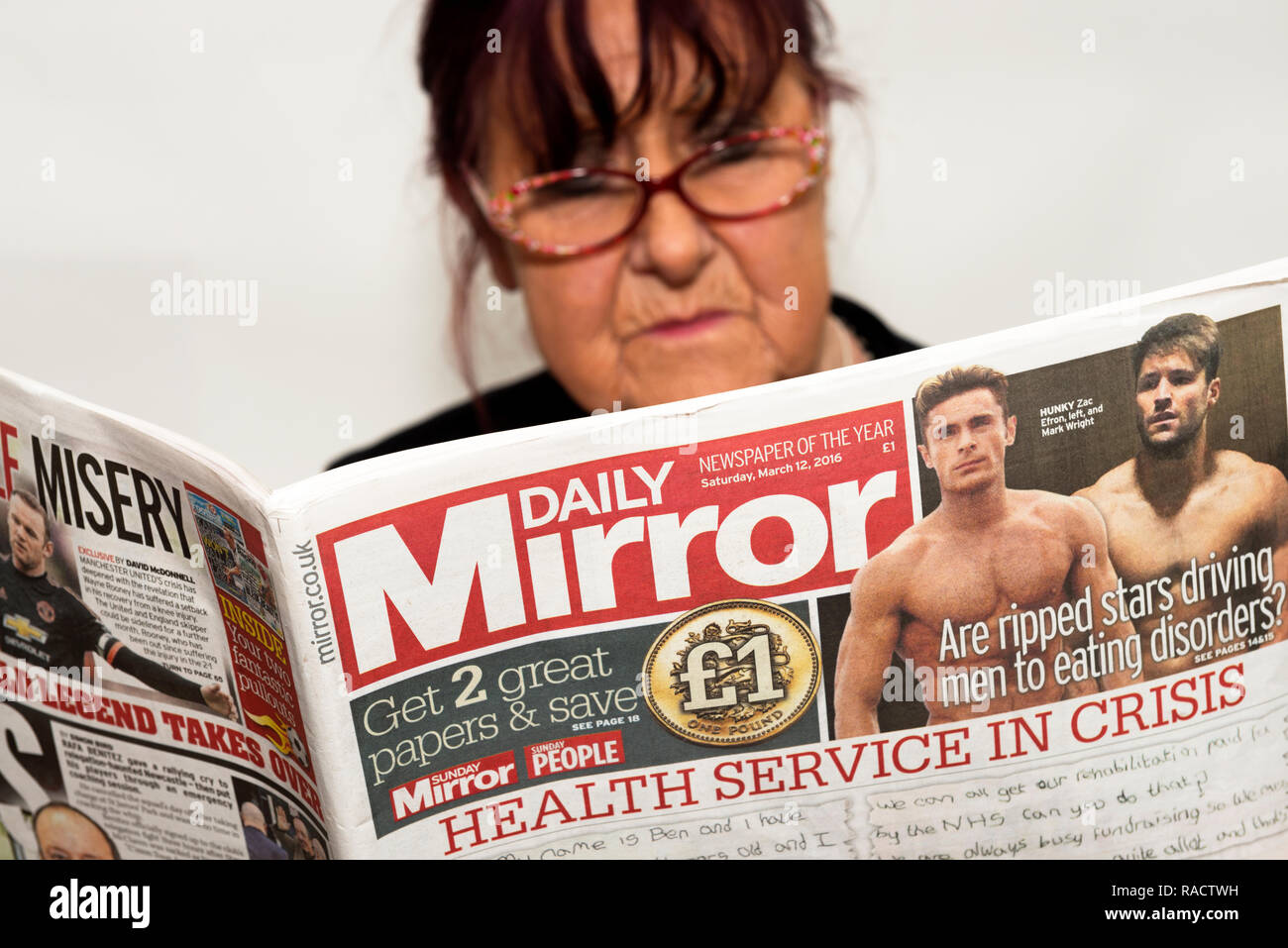 Woman reading the Daily Mirror newspaper Stock Photo