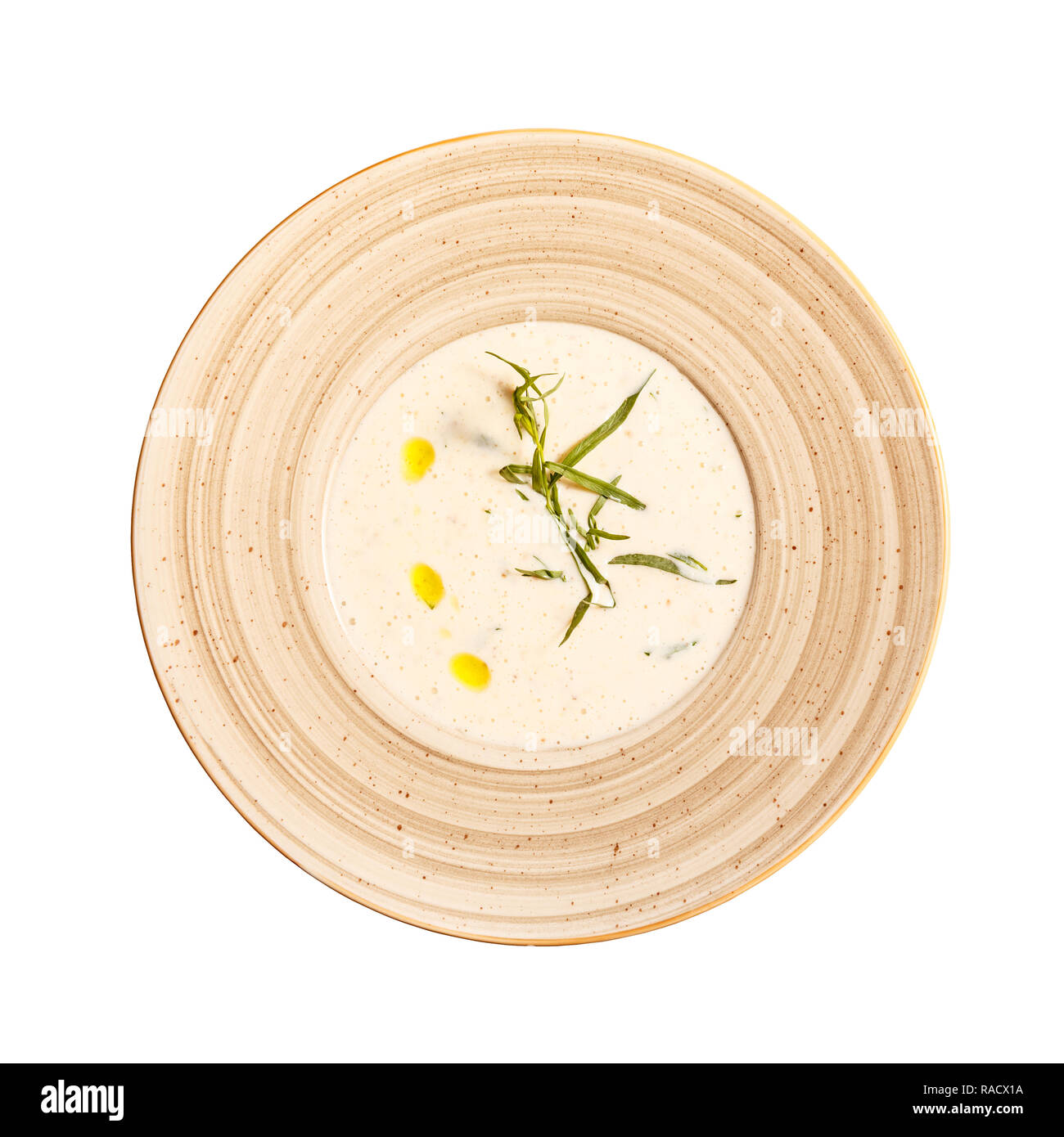 Flat lay of roasted potato cream soup with tarragon on white background Stock Photo