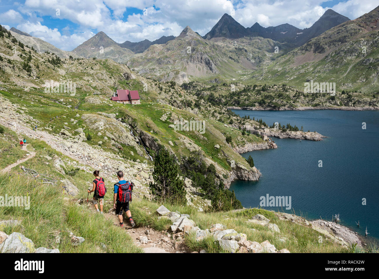 Hikers make their way along the the long distance footpath called the GR11 towards Refugio Respomuso in the Spanish Pyrenees, Huesca, Spain, Europe Stock Photo