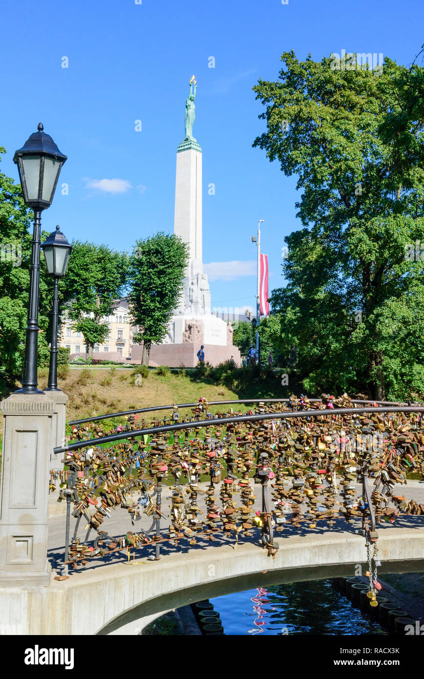 Freedom Monument and bridge with love lockets, Bastejkalna Parks, Riga, Latvia, Europe Stock Photo