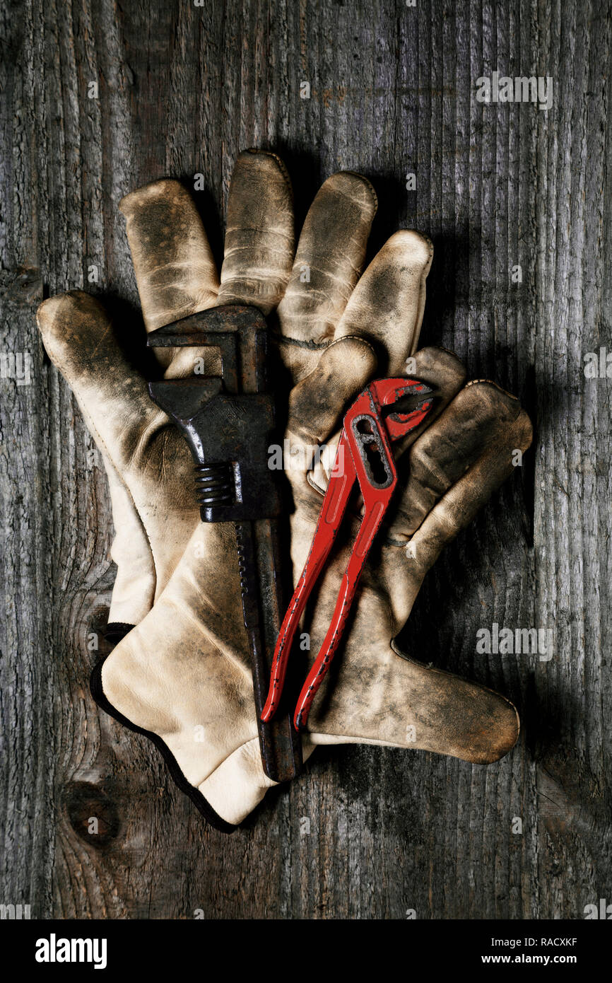 Old wrench on work glove Stock Photo