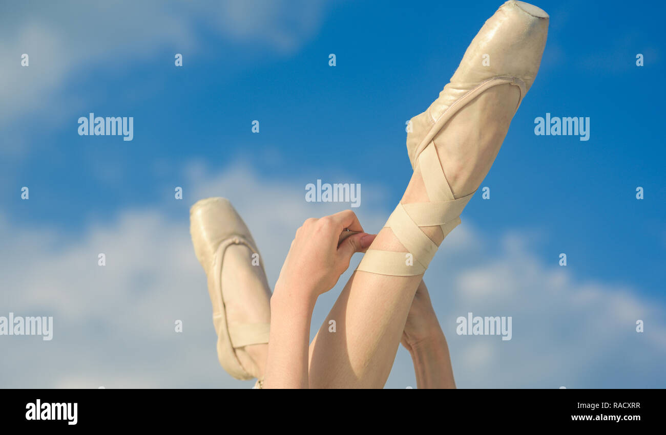 Accentuating the beauty. Ballet slippers. Ballerina shoes. Ballerina legs in ballet shoes. Feet in pointe shoes. Pointe shoes worn by ballet dancer. C Stock Photo