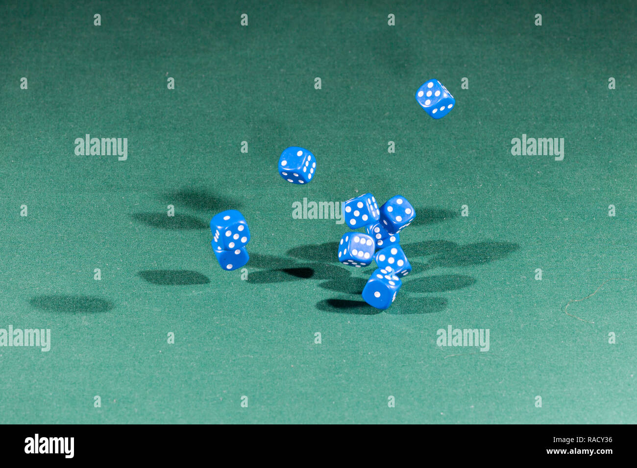 Ten blue dices falling on a green table Stock Photo