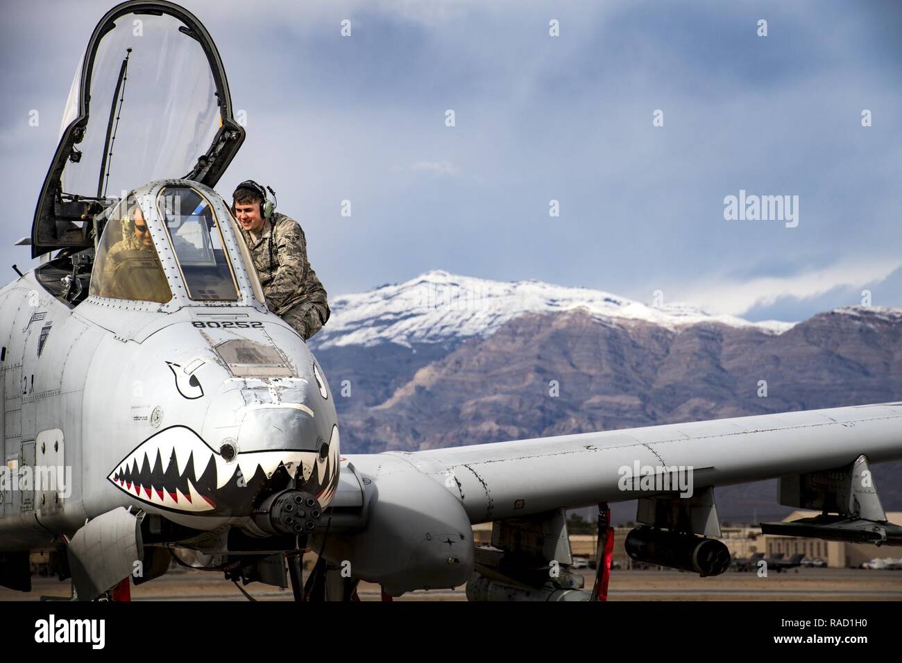 Airman 1st Class Devin Moore, right, 74th Aircraft Maintenance Unit avionics technician, speaks with a fellow maintainer while conducting maintenance on an A-10C Thunderbolt II during Green Flag-West 17-03, Jan. 23, 2017, at Nellis Air Force Base, Nev. GFW is an air-land integration combat training exercise, which hosted 12 A-10s from Moody Air Force Base, Ga. Accompanying the aircraft were 130 maintenance personnel who worked around the clock to launch 18 sorties per day. Stock Photo