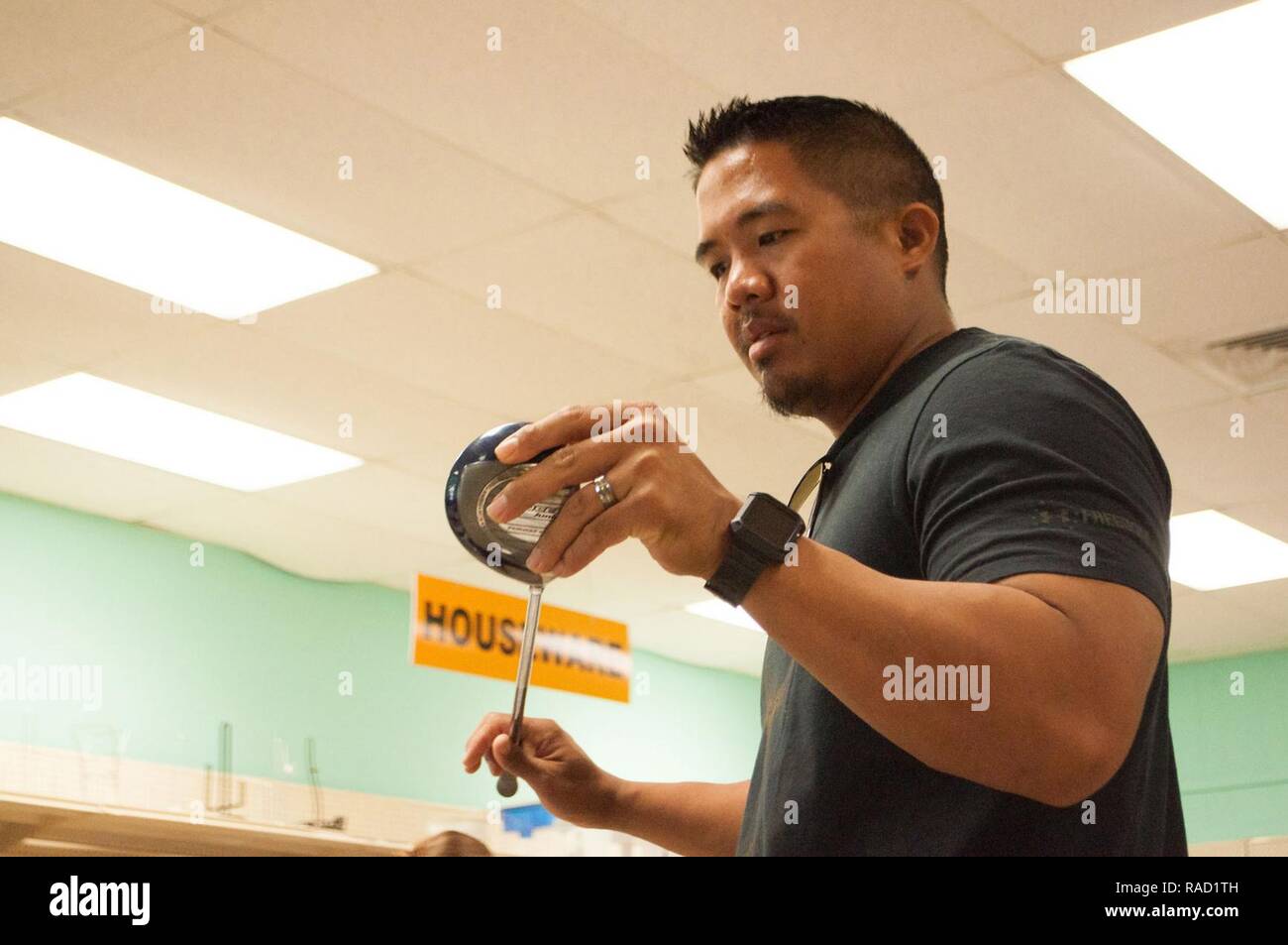 SCHOFIELD BARRACKS — Spc. Shaun Garcia, a civil affairs specialist with the 1st Battalion, 487th Field Artillery Regiment, browses through golf clubs at the Hui ‘O Na Wahine Thrift Shop here, Jan. 20, 2017. The Hui ‘O Na Wahine Thrift Shop, located at Schofield Barracks, has a selection of various household goods, including dishware, children’s items and clothes. Stock Photo