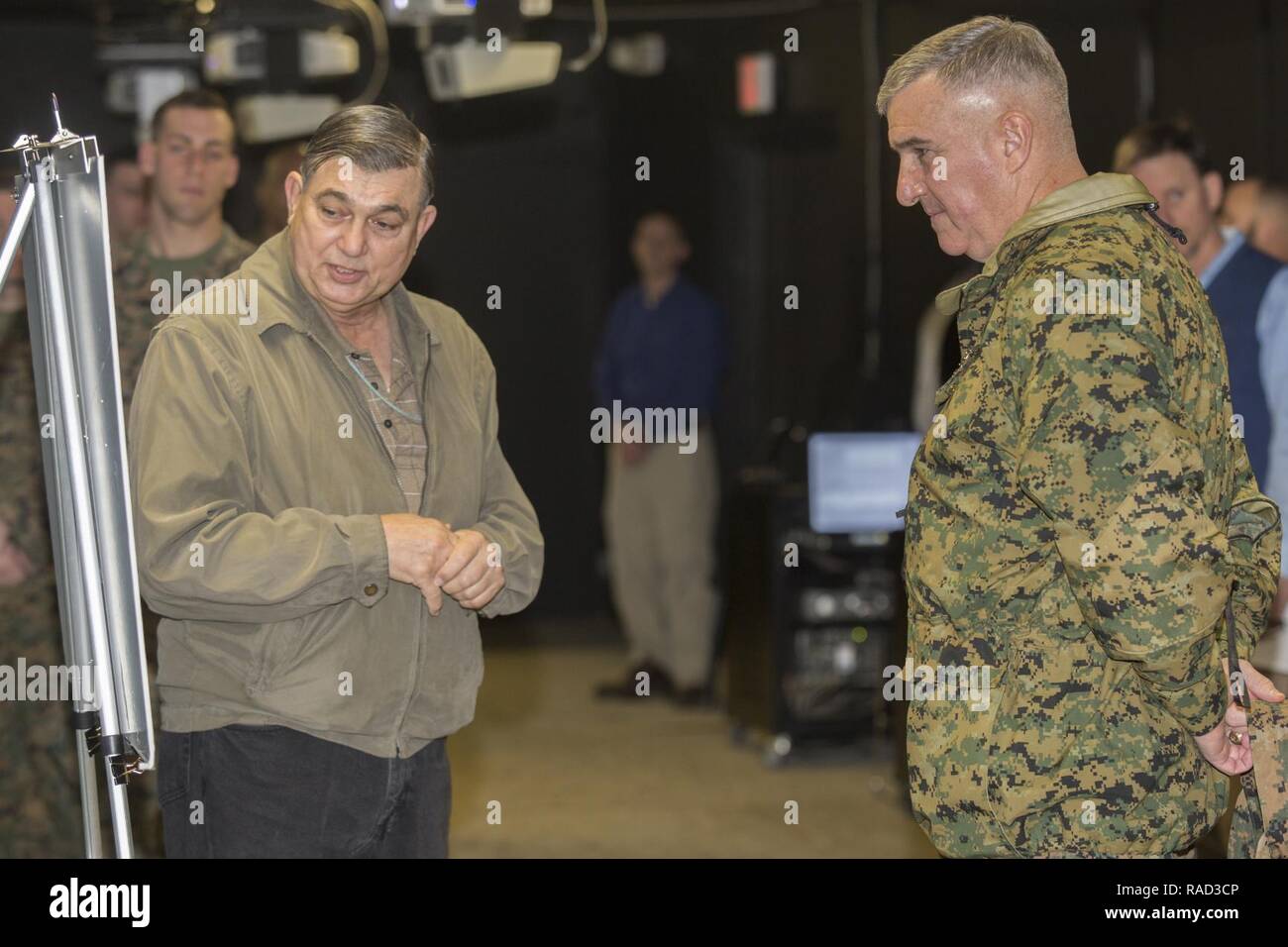 Mr. Joe Purcell, left, director of Training Support Division, Training and Education Command, briefs Gen. Glenn Walters the Assistant Commandant of the Marine Corps and senior leaders on the usage of simulator training systems during a visit to Camp Lejeune, N.C., Jan. 27, 2017. The purpose of the visit was to increase awareness and capabilities of ground simulation and simulator training systems in support of operational forces combat readiness. Stock Photo