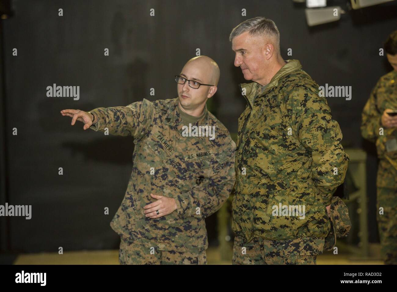 U.S. Marine Corps Sgt. Matthew N. Palmieri IV, left, rifleman, Division Combat Skills Center, Headquarters Battalion, 2nd Marine Division, briefs Gen. Glenn Walters the Assistant Commandant of the Marine Corps on the usage of simulator training systems during a visit to Camp Lejeune, N.C., Jan. 27, 2017. The purpose of the visit was to increase awareness and capabilities of ground simulation and simulator training systems in support of operational forces combat readiness. Stock Photo