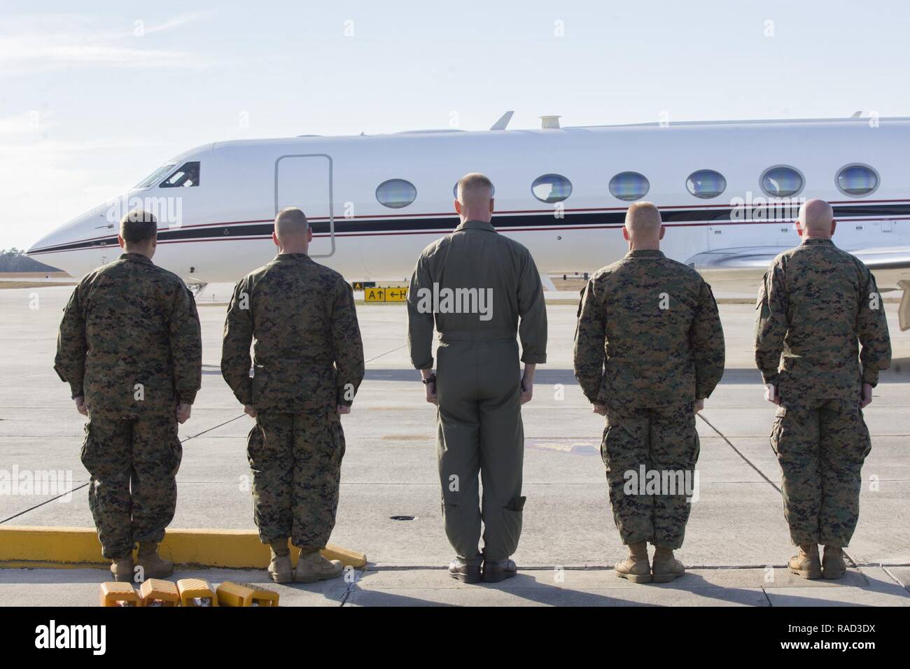 U.S. Marine Corps Maj. Gen. Walter L. Miller, commanding general, II Marine Expeditionary Force, and senior leaders stand at attention as Gen. Glenn Walters the Assistant Commandant of the Marine Corps departs Marine Corps Air Station New River, N.C., Jan. 27, 2017. The purpose of the visit was to increase awareness and capabilities of ground simulation and simulator training systems in support of operational forces combat readiness. Stock Photo