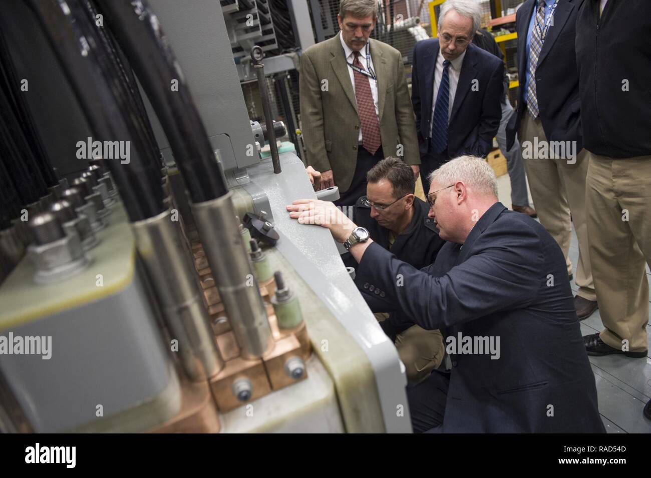DAHLGREN (Jan. 12, 2017) Tom Boucher, program manager for the Electromagnetic Railgun at the Office of Naval Research (ONR), talks to Rear Adm. David Hahn, chief of naval research, during a visit to the railgun facility located at Naval Surface Warfare Center, Dahlgren Division. Tom Boucher, second from right, program manager for the Electromagnetic Railgun at the Office of Naval Research (ONR), talks to Rear Adm. David Hahn, chief of naval research, during a visit to the railgun facility located at Naval Surface Warfare Center, Dahlgren Division. The EM Railgun launcher is a long-range weapon Stock Photo