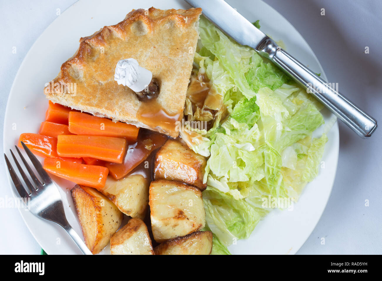 An English pub main course of Game pie served with shredded cabbage