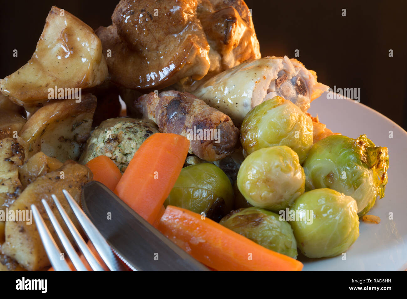 A popular British roast Chicken Sunday dinner with Yorkshire pudding, Stuffing, Pigs in blankets and potato and vegetables. Stock Photo