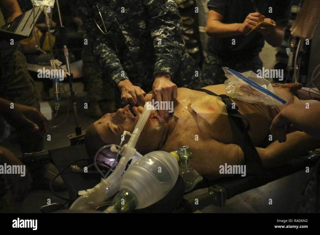 A Navy corpsman inserts a breathing tube to a notional patient as part of Naval Medical Augmentation Program training at Camp Lejeune, N.C., Jan. 26, 2017. The purpose of NMAP training is for corpsmen from different units to learn to work cohesively and be able to perform in an austere  environment. The Sailors are with 2nd Medical Battalion. Stock Photo