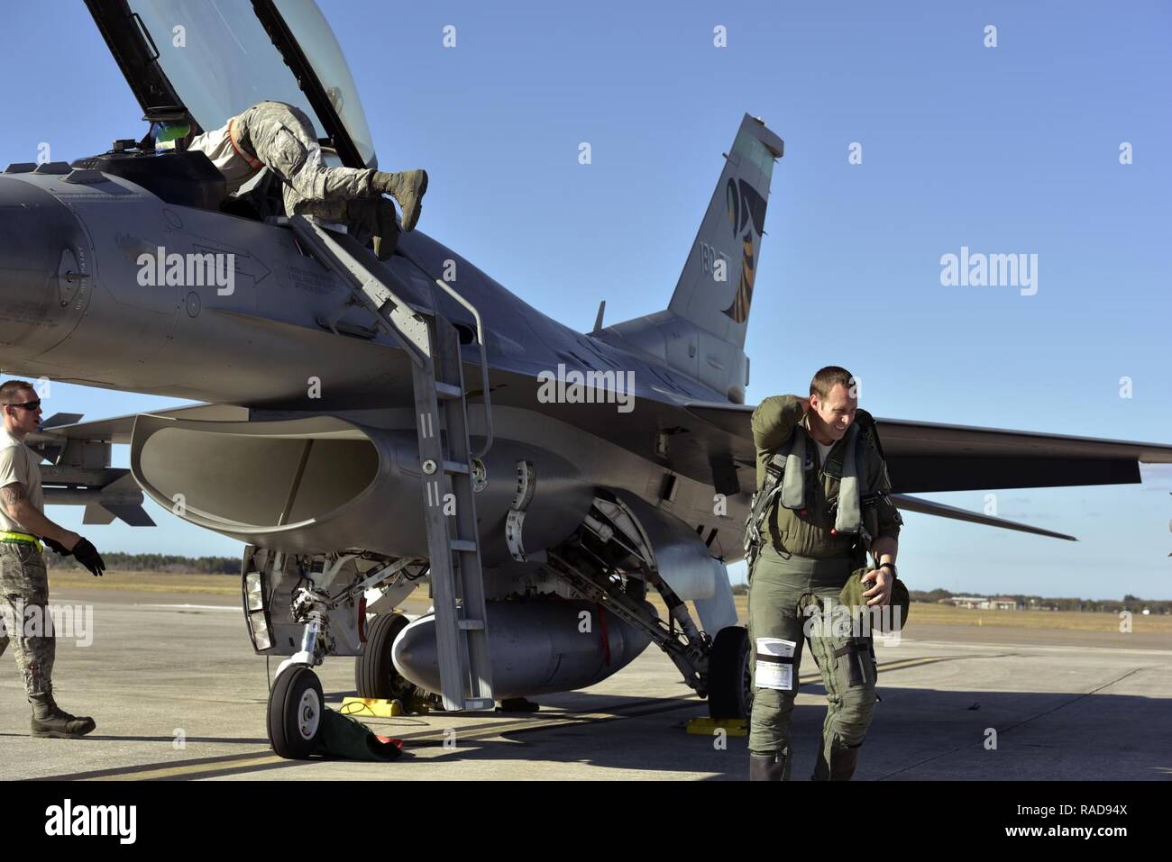U.S. Air Force Captain Jerad Ames, F-16 pilot assigned to the 180th Fighter Wing, Ohio Air National Guard, exits a jet after his landing as crew chiefs start a process of checking the jet for mechanical issues and preparing for the next flight, known as recovery, at MacDill Air Force Base in Tampa, Florida, on Jan. 31, 2017. The 180th brought their F-16s, maintainers, pilots and operations specialists for a two-week  training exercise at MacDill, which included basic fight maneuvers against F-18 Hornets from the Canadian 425th Tactical Fighter Squadron. (Air National Guard Stock Photo
