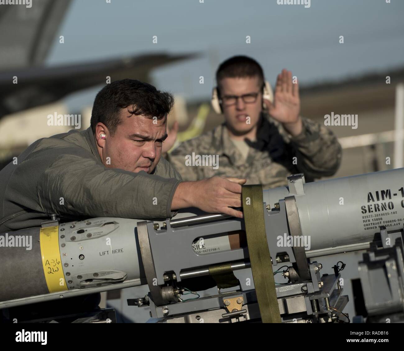 U.S. Air Force Staff Sgt. Brody Bundy, 33rd Aircraft Maintenance Squadron  weapons load crew chief, left, and Senior Airman Blake Baker, 33 AMXS  weapons load crewmember, secure a live AIM-120 advanced medium-range