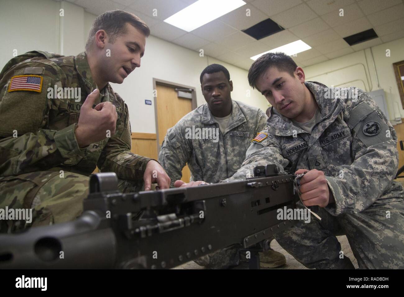 Army Cpl. Stephen Maklos, left, assigned to the 1st Battalion, 501st Parachute Infantry Regiment, 4th Infantry Brigade Combat Team (Airborne), 25th Infantry Division, U.S. Army Alaska, instructs Pfc. Timothy Hoffmann, right, assigned to the 574th Composite Supply Company, 17th Combat Sustainment Support Battalion, during weapons familiarization training at Joint Base Elmendorf-Richardson, Alaska, Feb. 1, 2017. The Soldiers, from Fort Wainwright and JBER, participated in a week-long combat skills training exercise in preparation for an upcoming deployment. Stock Photo