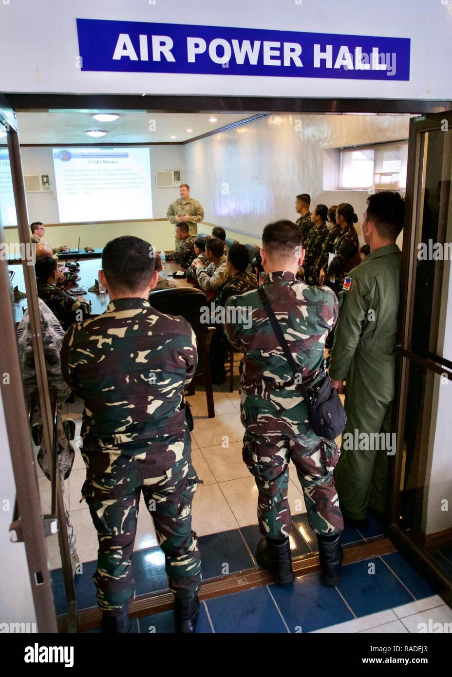 U.S. Army Sgt. 1st Class Justin Kunzman, a senior geospatial engineer with the 5th Engineer Detachment Geospatial Planning Cell, briefs a team of U.S. and Philippine service members as part of the Eagle Vision Subject Matter Expert Exchange table-top simulation, Clark Air Base, Philippines, Jan. 25, 2017. The simulation was the capstone event of a two-week long SMEE. The SMEE focused on a how satellite imagery and geospatial information can enhance combined Humanitarian Assistance and Disaster Relief operations between the U.S. and the Philippines. Stock Photo