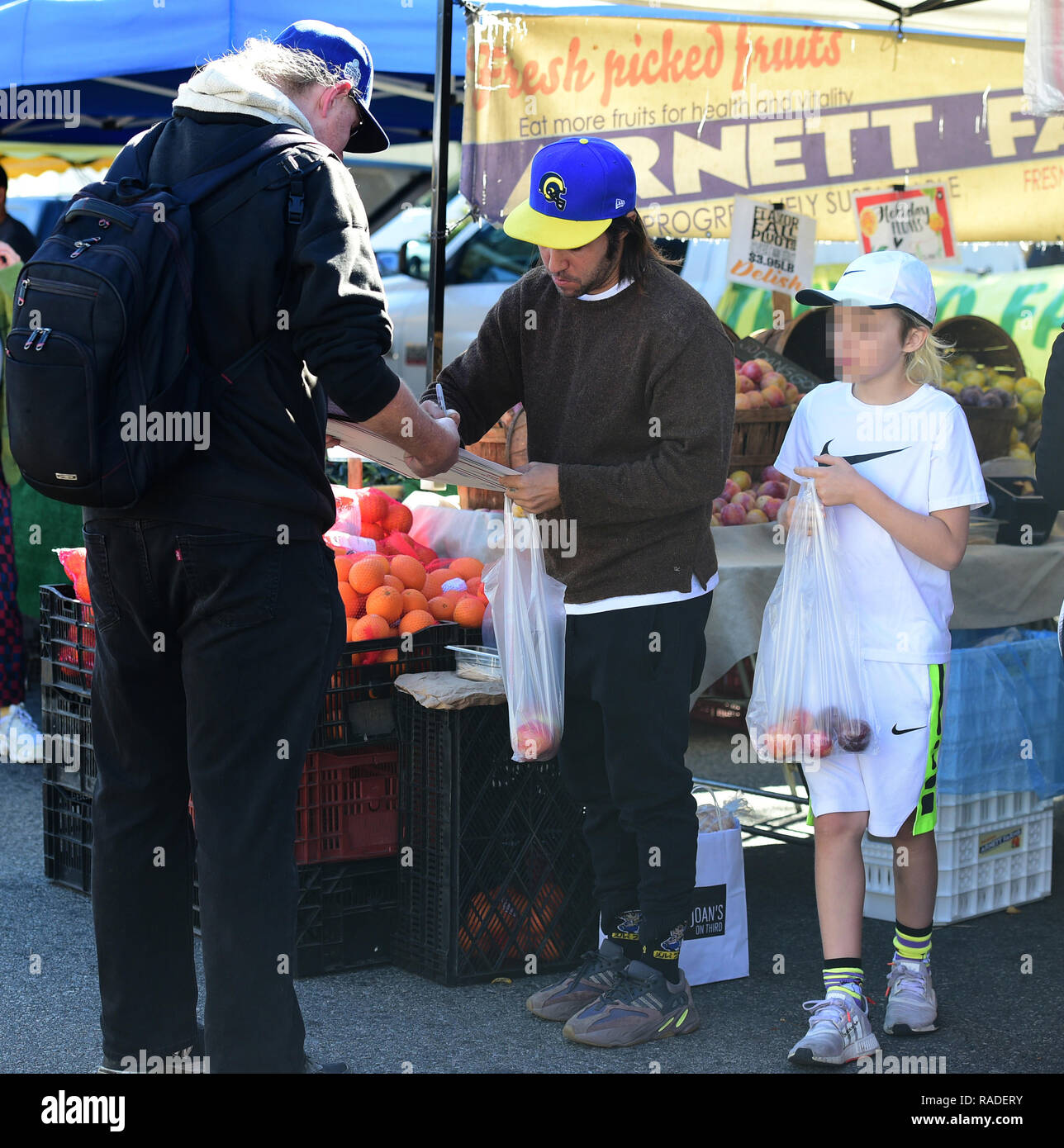 Pete Wentz signs an autograph for a fan while his son Bronx Wentz looks