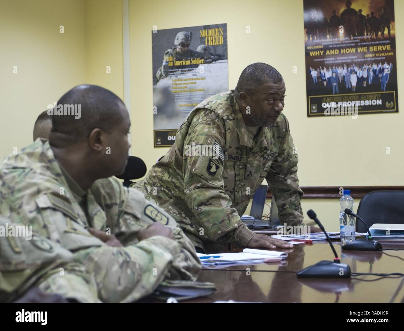 Rick Gravely, the 1st Sustainment Command (Theater) deputy safety director, (right), talks about the 2017 Worldwide Ammunition Logistics and Explosives Safety Review timeline in Camp Arifjan, Kuwait, on Jan. 20, 2017. The review, conducted by the U.S. Army Defense Ammunition Center, will carry out evaluations against a recognized standard, provide solutions to resolve issues or problems, teach and enhance knowledge base and to emphasize the fact that the reviews are not punitive in nature. Stock Photo