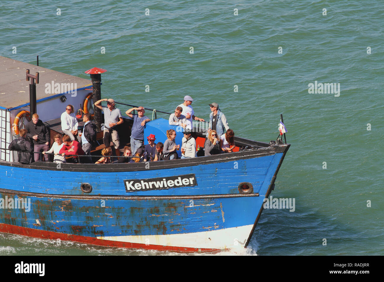 Warnemunde, Rostock, Germany - Jul 06, 2018: Passengers on fore of small vessel Stock Photo