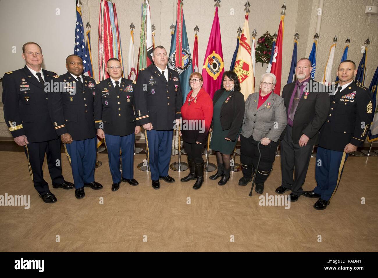 The seven retirees participating in an island-wide retirement ceremony stand with Maj. Gen. Duane Gamble (left), commanding general, U.S. Army Sustainment Command, and Command Sgt. Maj. Joe Ulloth (right), command sergeant major, ASC, following award recognitions Dec. 13 in Heritage Hall, Rock Island Arsenal. Stock Photo