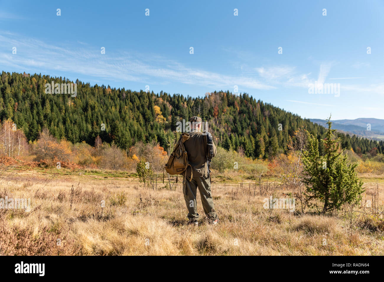 Hunter is looking a place for ambush, mountain hunting, forestland. Stock Photo
