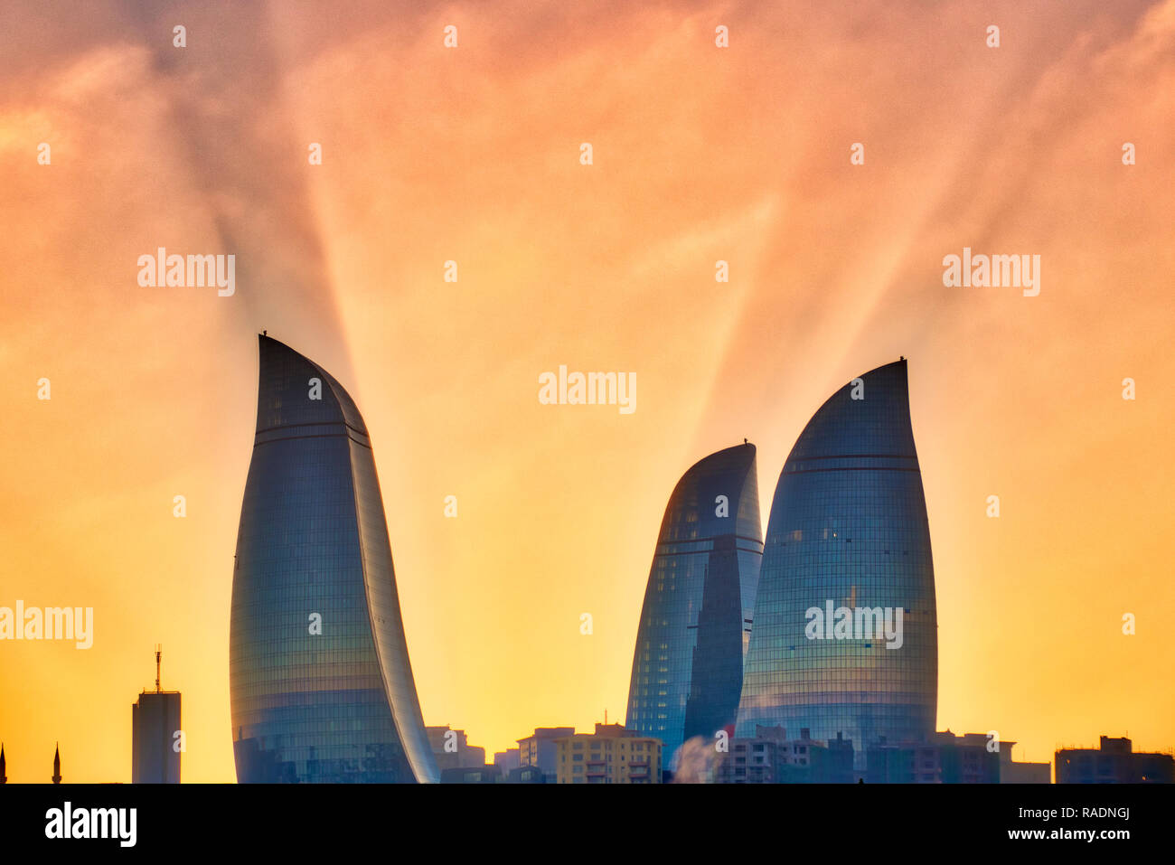 Sun rays behind Flame Towers, Baku, Azerbaijan Stock Photo