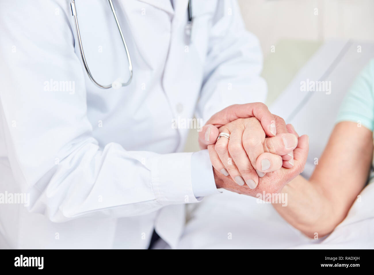 Doctor holds the hand of a patient as a sign of comfort and care Stock Photo