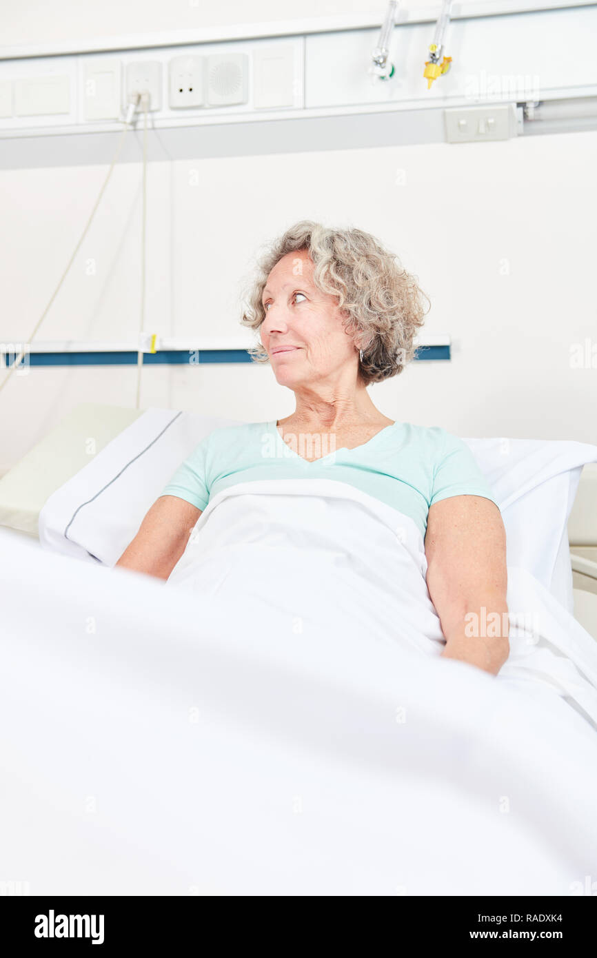 Sick senior woman lying in hospital bed in hospital or in a rehab clinic Stock Photo