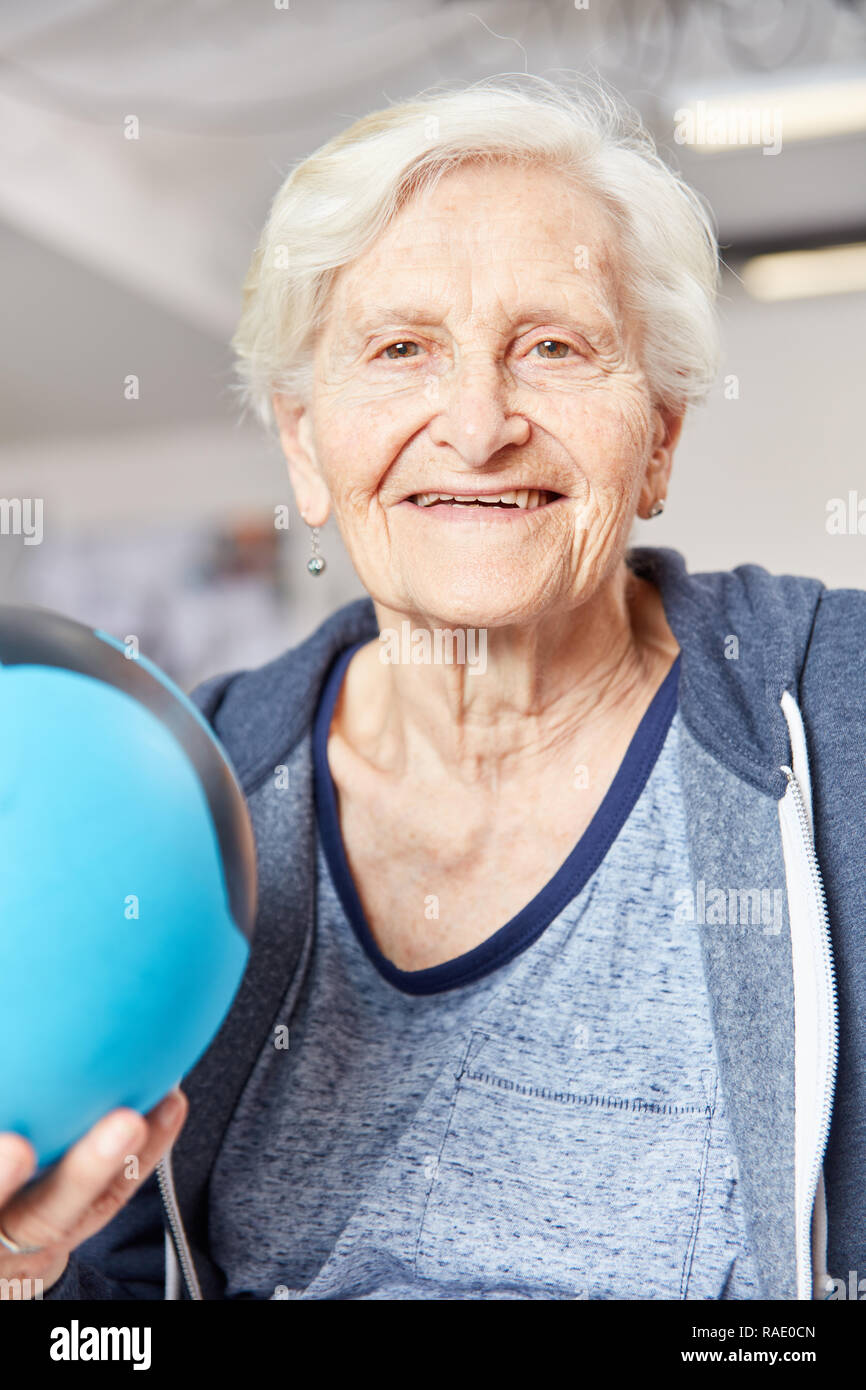 Happy senior woman with ball in occupational therapy as a rehab in the