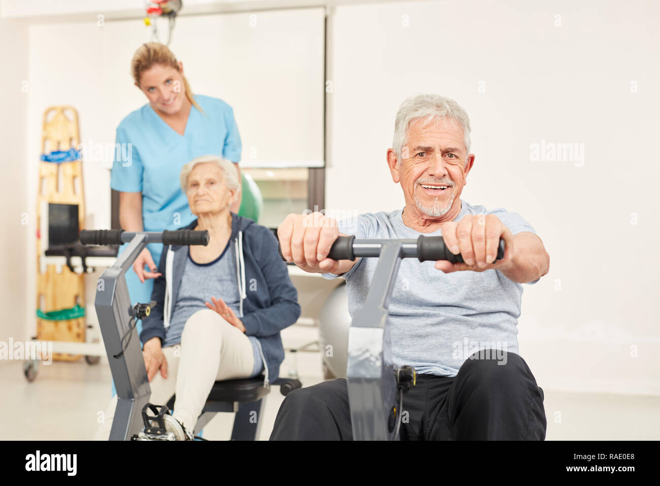 Senior couple trains rehab fitness on the exercise bike at the fitness center Stock Photo