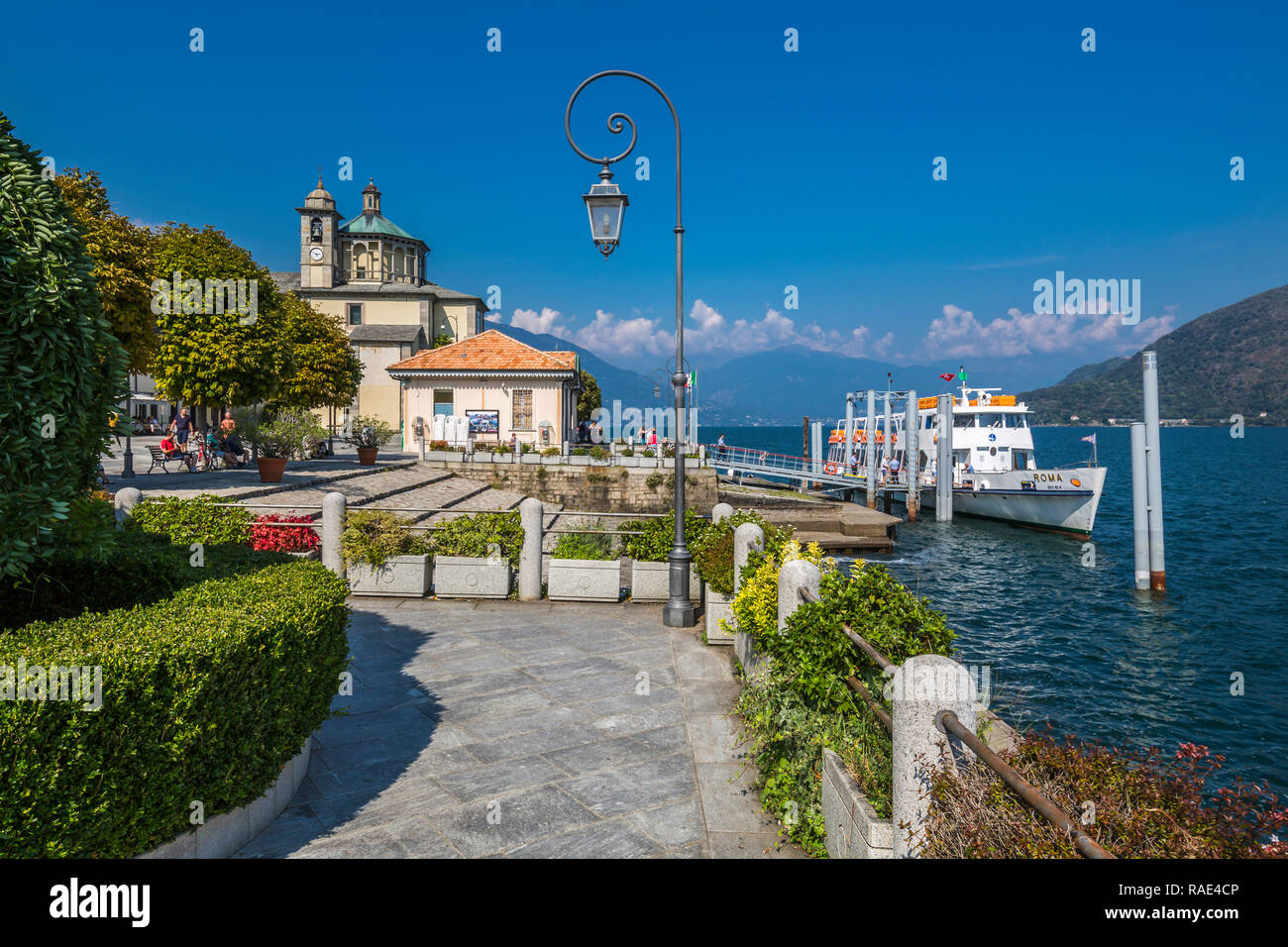 Cruiseboat moored near harbour and Santuario della SS Pieta Church in Cannobio, Lake Maggiore, Piedmont, Italian Lakes, Italy, Europe Stock Photo
