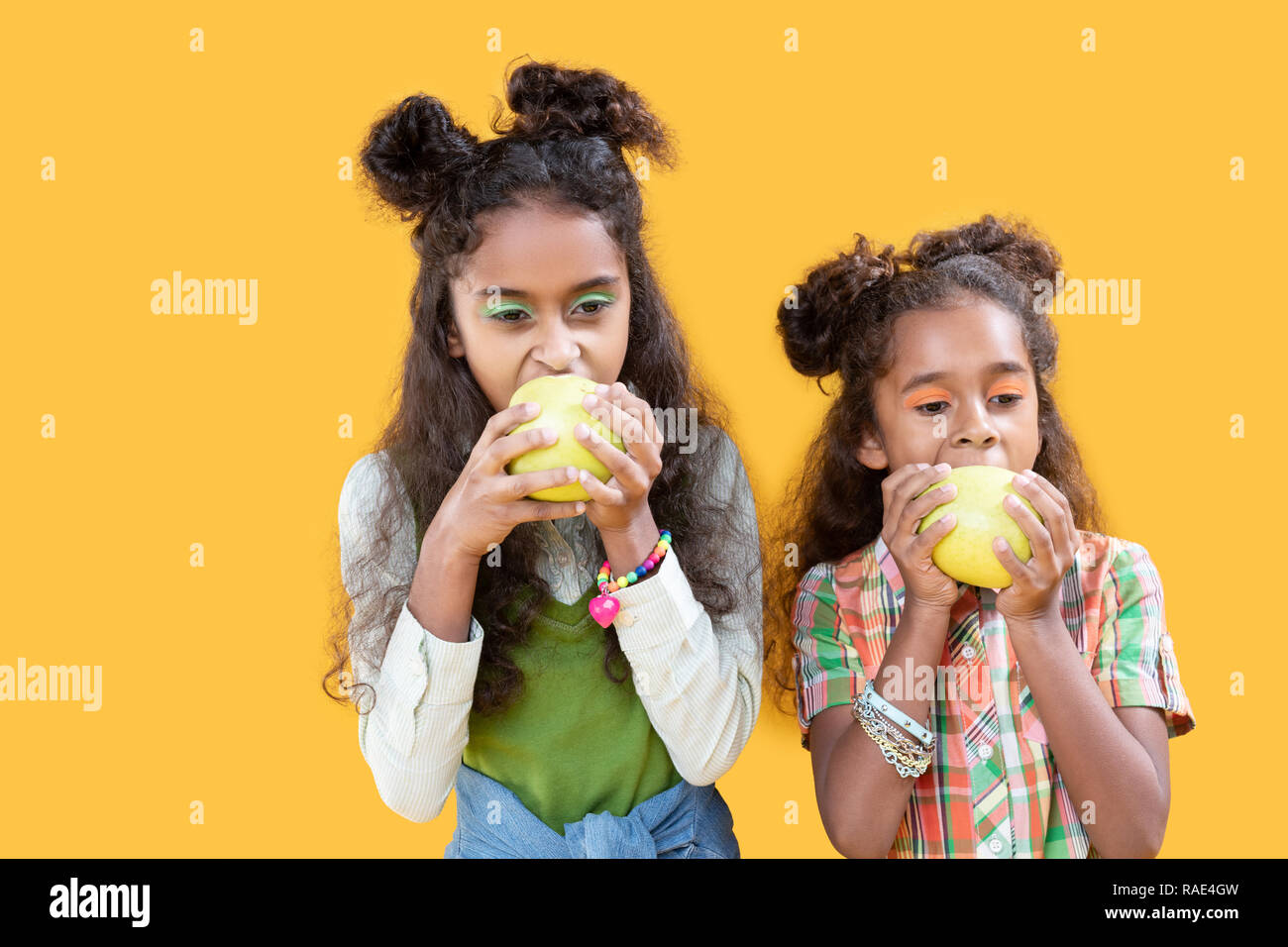 Nice afro american girls biting their apples Stock Photo