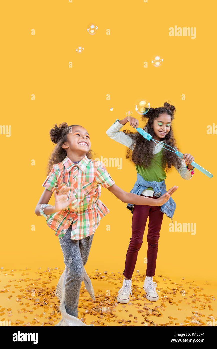 Delighted happy girls playing with soap bubbles Stock Photo