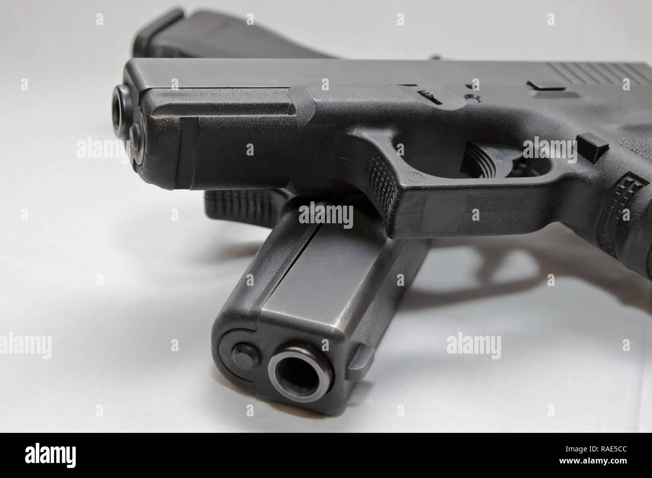 Two black semi automatic pistols, a 9mm and a 40 caliber with one on top of the other on a white background Stock Photo