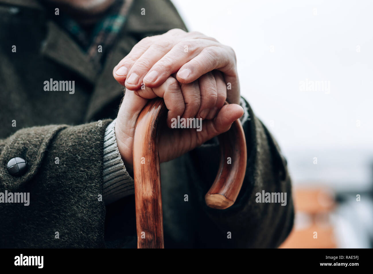 Upset mature male holding walking stick in both hands Stock Photo Alamy